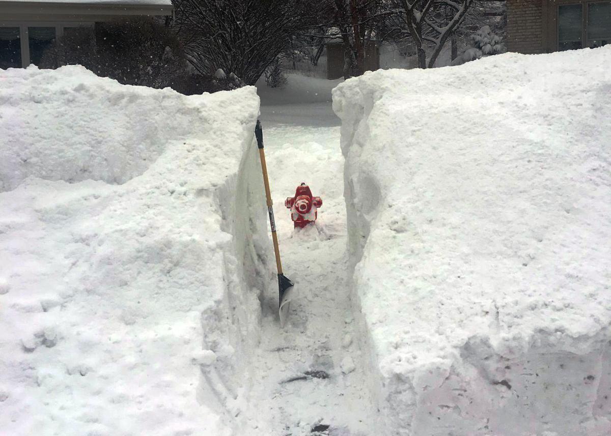 A hydrant in snowy weather, with a path cleared to it. 